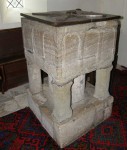 a square font, with 3 classic arches dipicted on each side, supported on 3 corner columns and a central column
